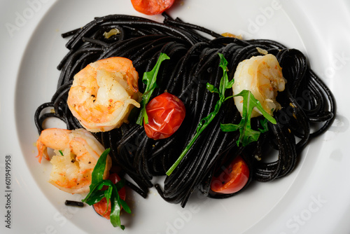 Spaghetti al Nero di Seppia con Gamberi, Italian Pasta with Squid Ink, Prawns, Tomato and Rucola photo