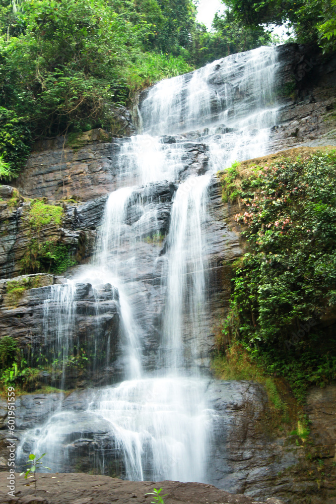 Beautiful hidden waterfall in mountains. Slow shutter speed. Waterfall portrait