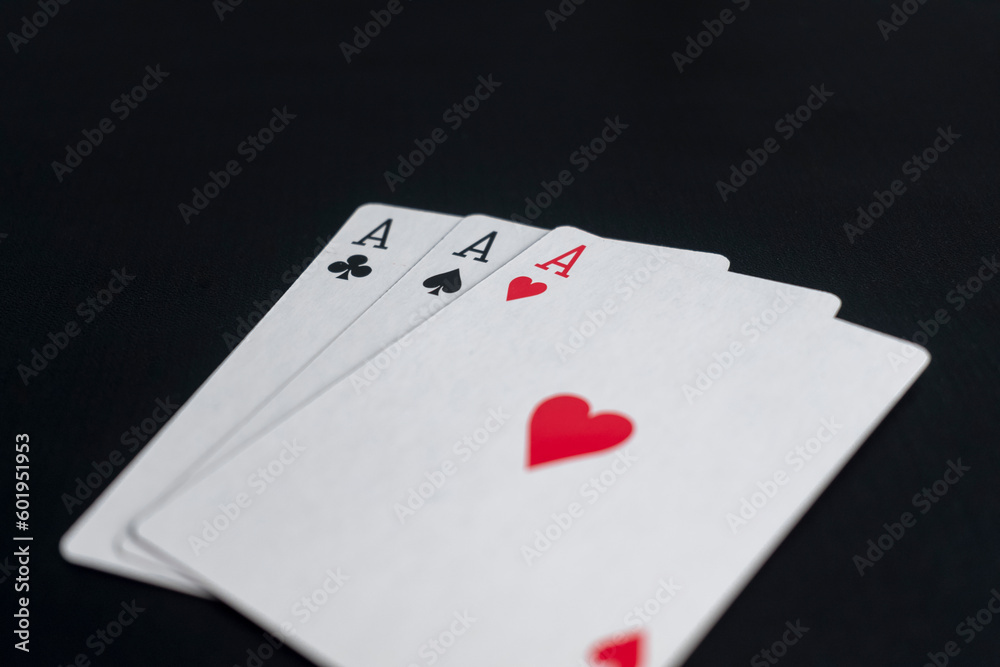 triple aces of playing cards on black background