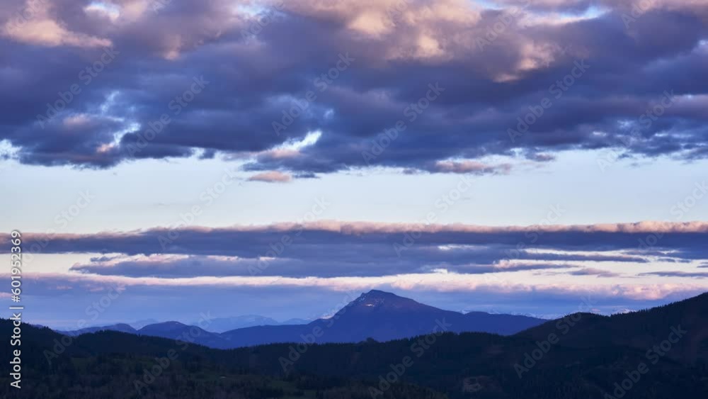 Hilly mountain scenery. Clouds forming over the mountain on the horizon. Pastel colored clouds