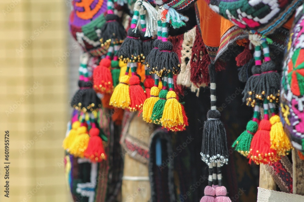 Colored woolen goods in the Asian market. Fringe on pendants to scare away evil spirits from the house. National amulets of Central Asia.