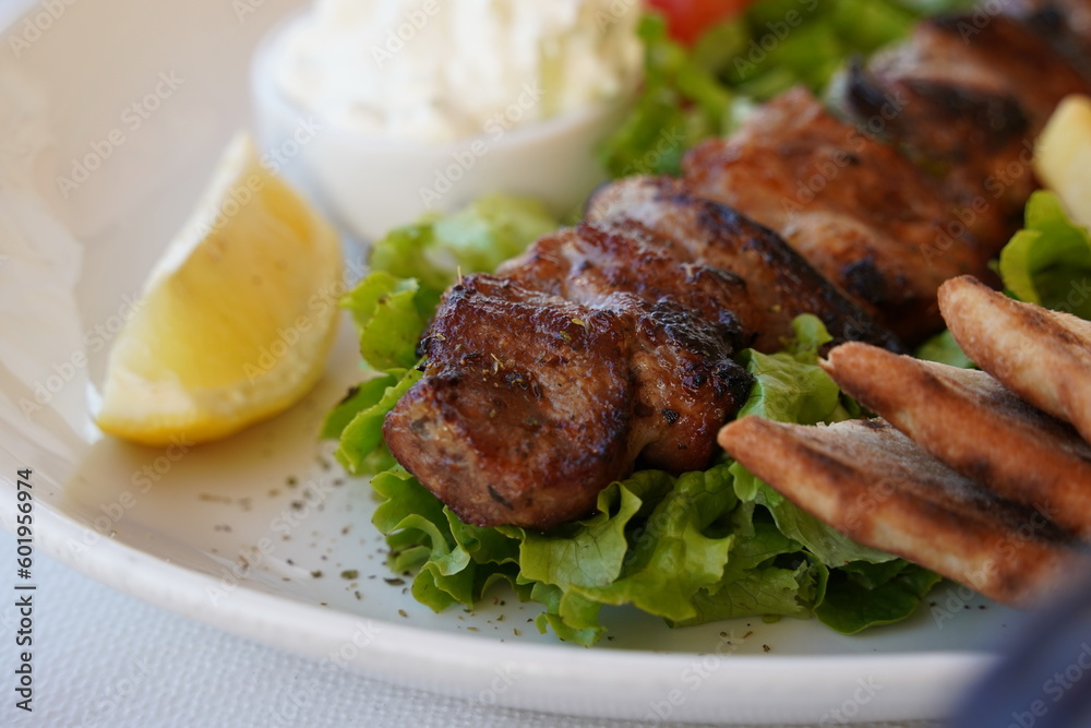 Souvlaki, meat skewers, traditional Greek  meat food on pita bread, tzatziki sauce and potatoes