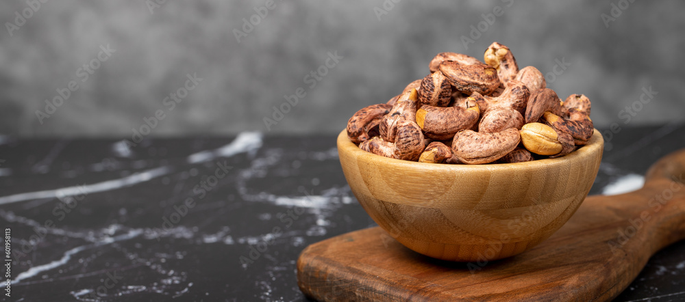 Cashew nuts . Roasted cashew nuts with shell in wooden bowl. Superfood. Vegetarian food concept. Healthy snacks. Copy space. Empty space for text Cashew nuts . Roasted cashew nuts with shell in wooden bowl. Superfood. Vegetarian food concept. Healthy snacks. Copy space. Empty space for text