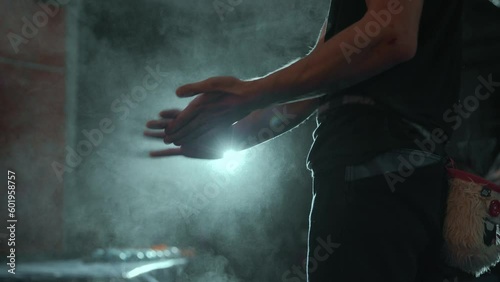 Sports athletic man uses magnesium for hands, close-up. Dust flies from talcum powder, white chalk powder. Hobby in the city, healthy lifestyle. High quality 4k footage