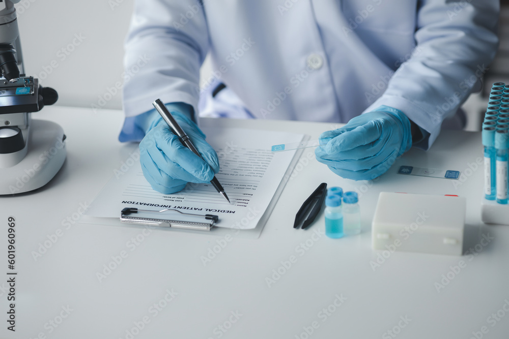 Lab assistant, medical scientist, chemistry researcher holds a glass tube through a chemical test tube, does a chemical experiment and examines a patient's sample. Medicine and research concept. Lab assistant, medical scientist, chemistry researcher holds a glass tube through a chemical test tube, does a chemical experiment and examines a patient's sample. Medicine and research concept.