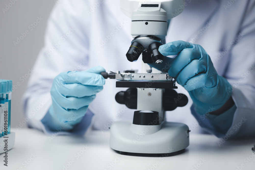 Lab assistant, medical scientist, chemistry researcher holds a glass tube through a chemical test tube, does a chemical experiment and examines a patient's sample. Medicine and research concept.