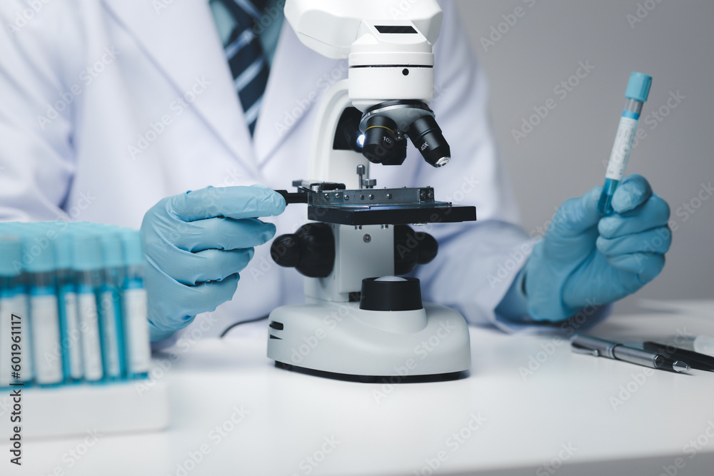 Lab assistant, medical scientist, chemistry researcher holds a glass tube through a chemical test tube, does a chemical experiment and examines a patient's sample. Medicine and research concept. Lab assistant, medical scientist, chemistry researcher holds a glass tube through a chemical test tube, does a chemical experiment and examines a patient's sample. Medicine and research concept.