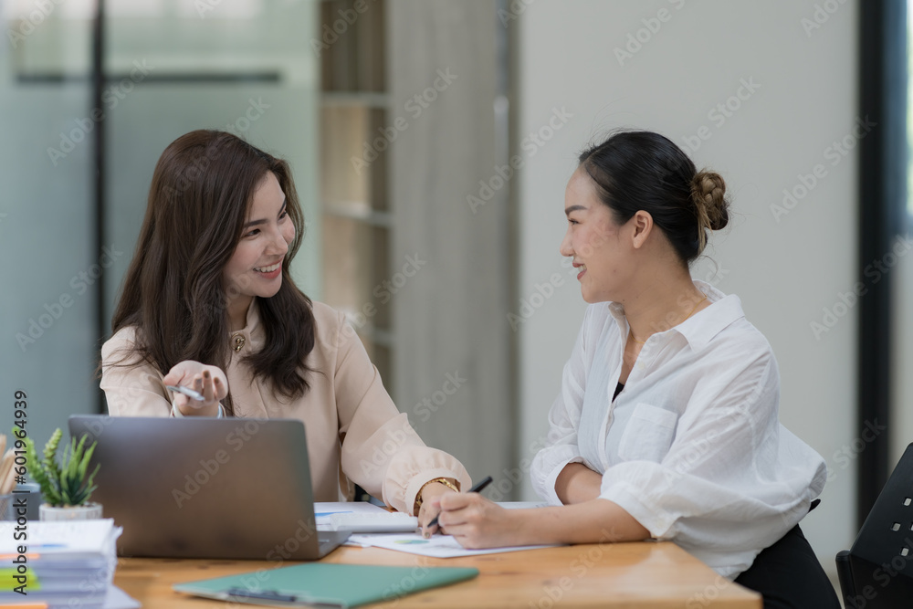 Two Young Asian businesswomen discuss with new startup project Idea presentation and analyze planning and financial statistics and investment market at an office. Two Young Asian businesswomen discuss with new startup project Idea presentation and analyze planning and financial statistics and investment market at an office.