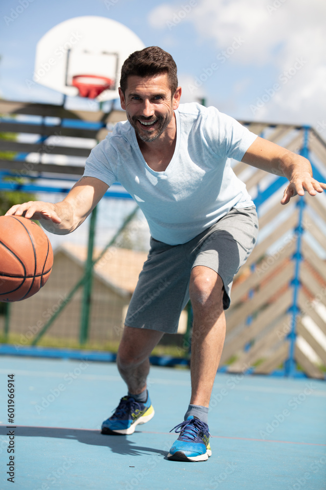 fit male playing basketball outdoor