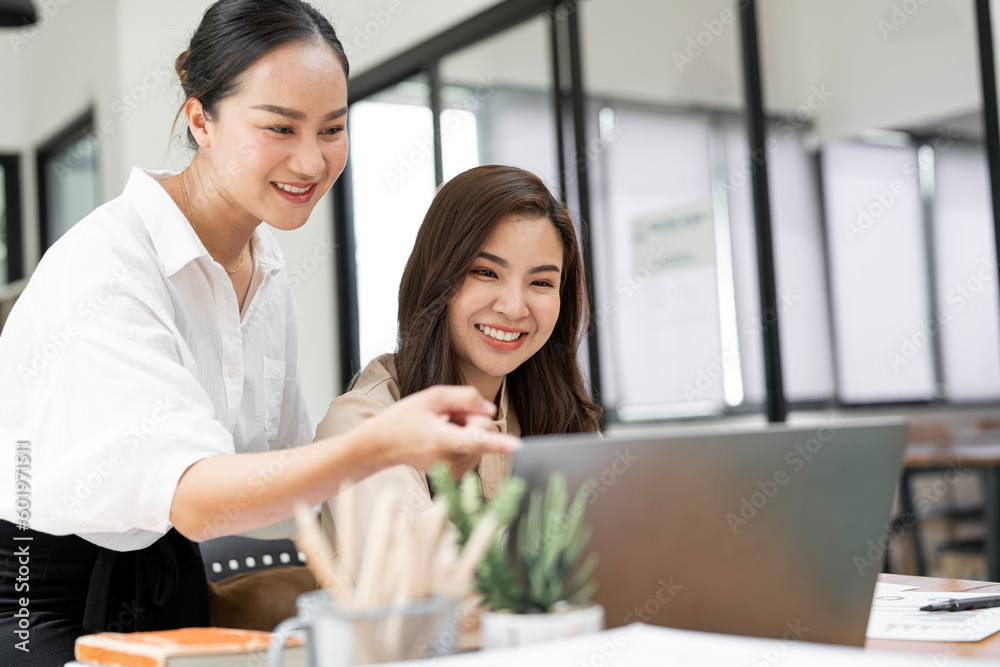 Two young woman working together, smiling and laughing with happiness at office. Two young woman working together, smiling and laughing with happiness at office.