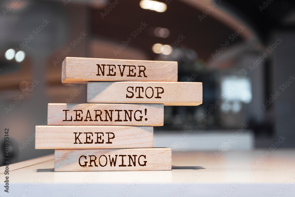 Wooden blocks with words 'Never stop learning. Keep growing'.