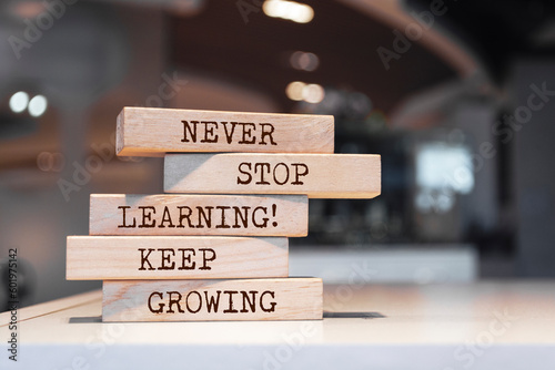 Wooden blocks with words 'Never stop learning. Keep growing'.