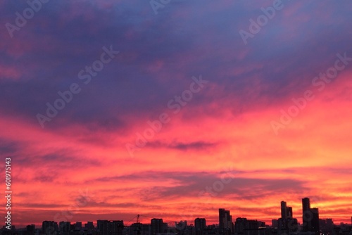 Colorful cloudy twilight beautiful sky cityscape sunset and morning sunrise. Dramatic evening night early morning view with city buildings silhouette. Panoramic background concept. Copy space for text