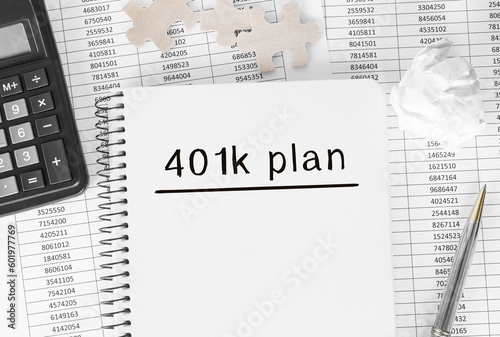 Notebook with word 401k plan on financial background photo