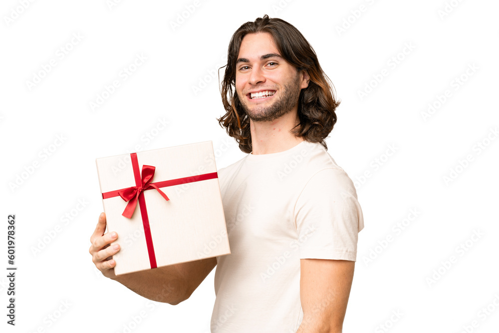 Young handsome man holding a gift over isolated background smiling a lot Young handsome man holding a gift over isolated background smiling a lot