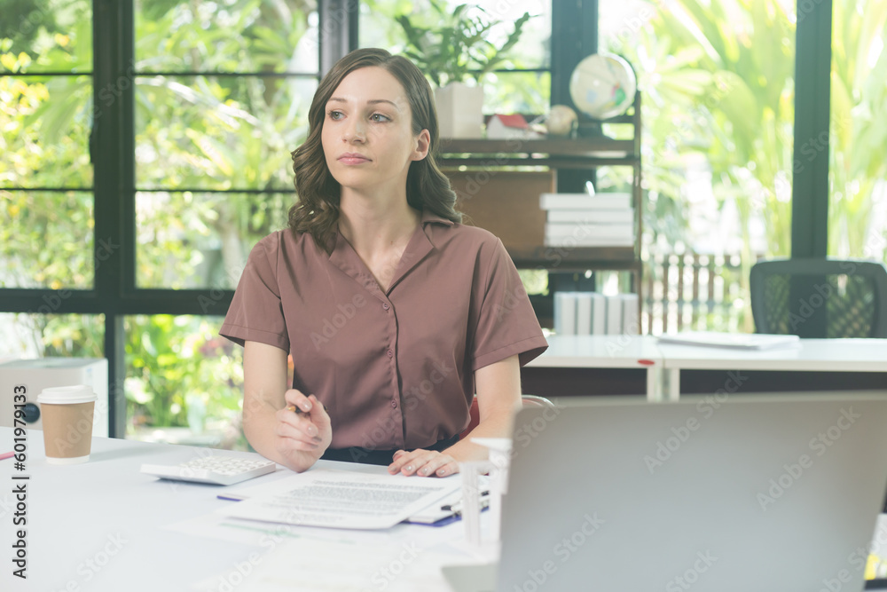 Shot of an attractive mature businesswoman working on laptop in her workstation. Shot of an attractive mature businesswoman working on laptop in her workstation.