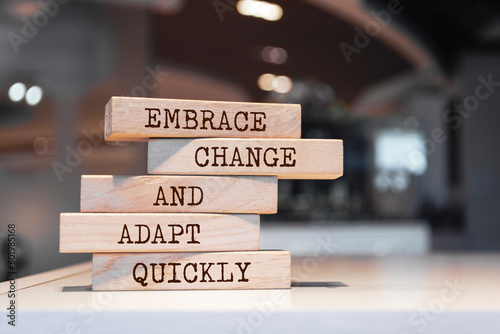 Wooden blocks with words 'Embrace change and adapt quickly'.