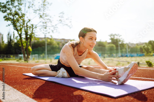 Young woman in sports outfit doing exercises outdoors in the morning. Sport, Active life, sports training, healthy lifestyle.