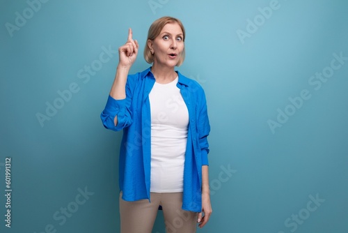 smart mature woman thinking brilliant idea on blue background with copyspace