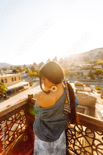 Young woman meditates on a terrace with stunning city views in Cappadocia. Active lifestyle, vacation, resting.