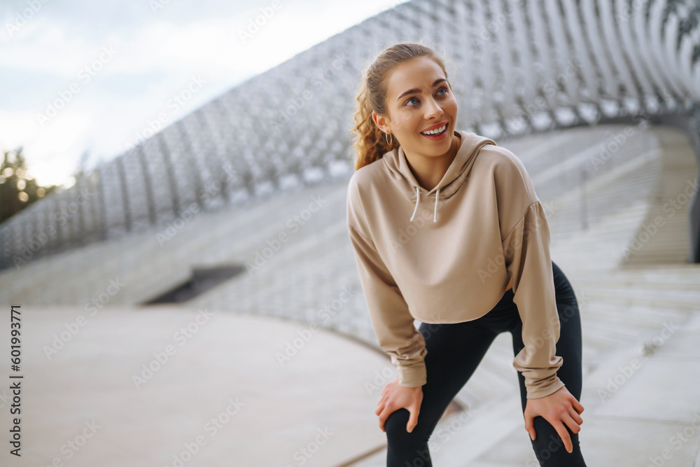Young woman in sports outfit doing exercises outdoors in the morning. Concept of sports, sports training, yoga or fitness. Young woman in sports outfit doing exercises outdoors in the morning. Concept of sports, sports training, yoga or fitness.