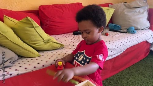 3-year-old smart black child playing with his wooden toy tools at home. photo