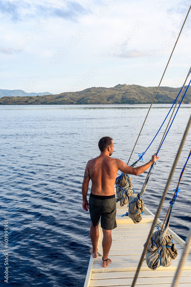 a man is posing sailing on a yacht ship