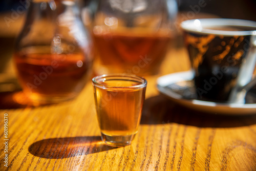 Fototapeta Naklejka Na Ścianę i Meble -  A glass of old brandy on the table...blurred background...morning drink brandy and coffe...