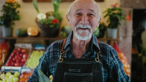 Senior greengrocer working at the market holding a box containing fresh fruits and vegetables - Food retail worker concept