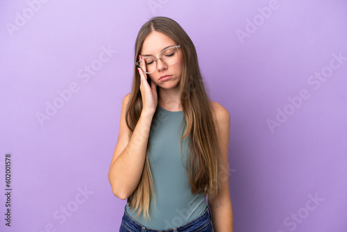 Young Lithuanian woman isolated on purple background with headache