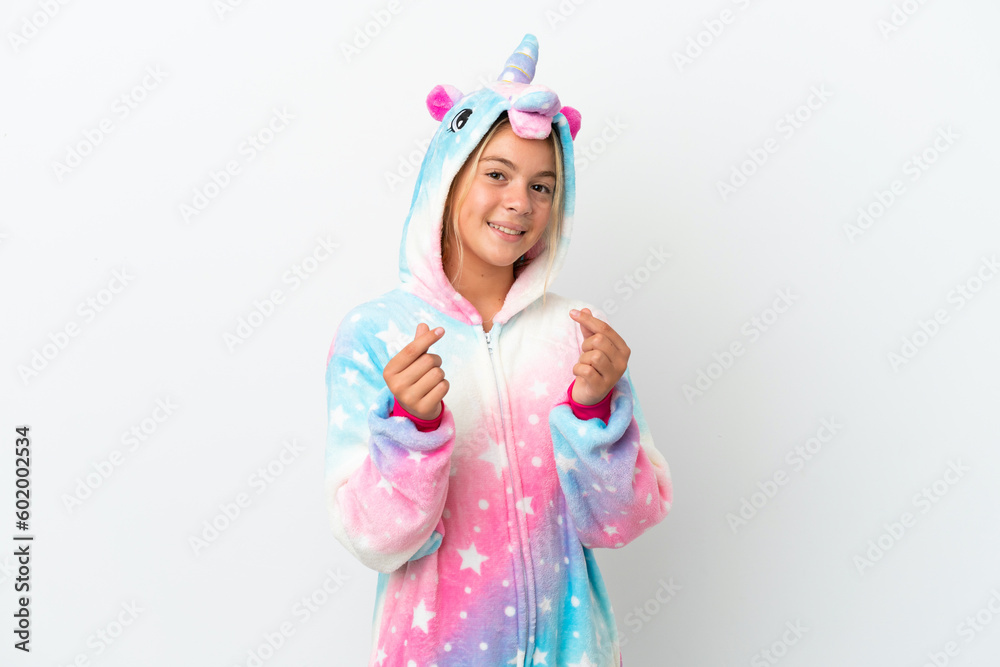 Little girl with unicorn pajamas isolated on white background making money gesture Little girl with unicorn pajamas isolated on white background making money gesture
