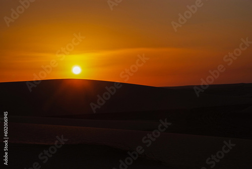 Sunset and sunrise in the desert with beautiful sand dunes behind it  © Aziz