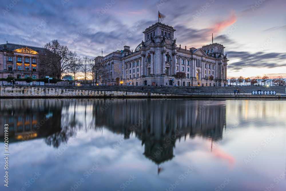 Sunset in Berlin. Government district with buildings. Reichstag in the evening. River Spree with reflection on the water surface. Evening mood in the capital of Germany in winter