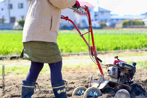 家庭菜園で野菜作りをする女性　農業女子　耕運機で畑を耕す女性 photo