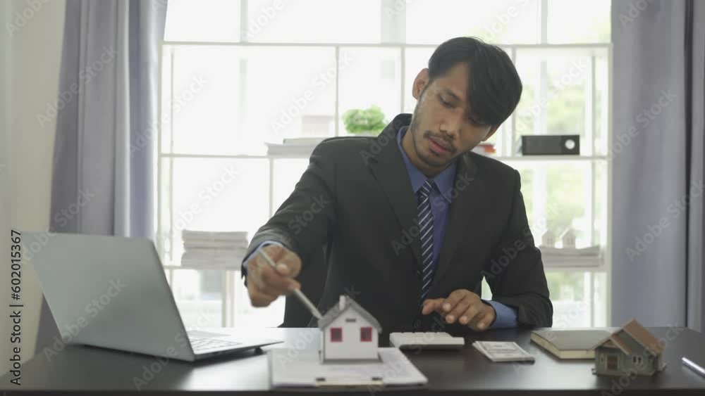 A real estate agent explains the interest rate to a new home buyer about the terms of the home purchase agreement. A real estate agent explains the interest rate to a new home buyer about the terms of the home purchase agreement.