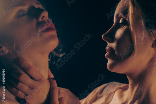 Couple of young blonde women approaching for a romantic kiss (2/6)