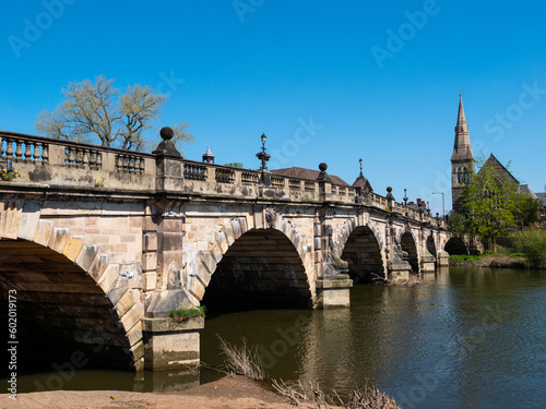 The stone arches of the 18th century Grade II listed English Bridge which crosses the River Severn in Shrewsbury, UK. Clear blue sky. Space for text.