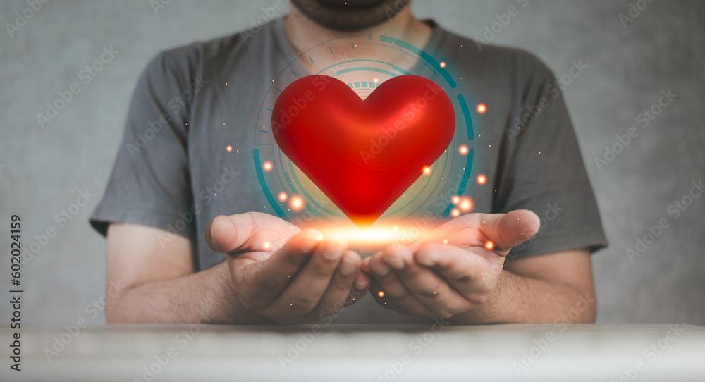Hands cupped and holding or showing red hearts with bright, glowing, shining light. The concept for offering or donating giving heart Hands cupped and holding or showing red hearts with bright, glowing, shining light. The concept for offering or donating giving heart