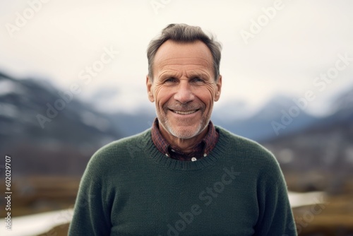 Portrait of smiling senior man looking at camera in the mountains.