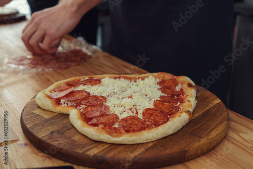 Male hands preparing pizza in the shape of a heart for a romantic gift