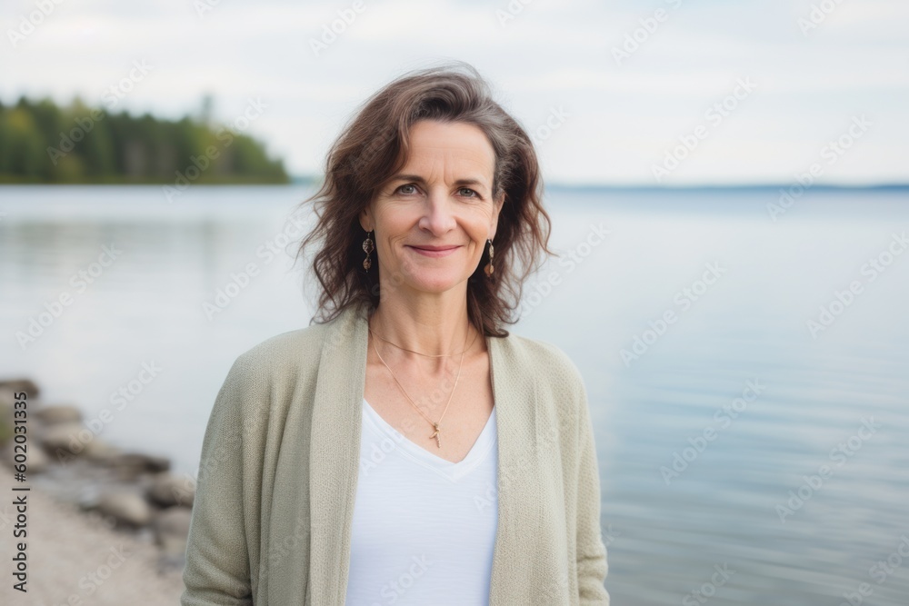 Portrait of a beautiful middle-aged woman on the background of the lake Portrait of a beautiful middle-aged woman on the background of the lake
