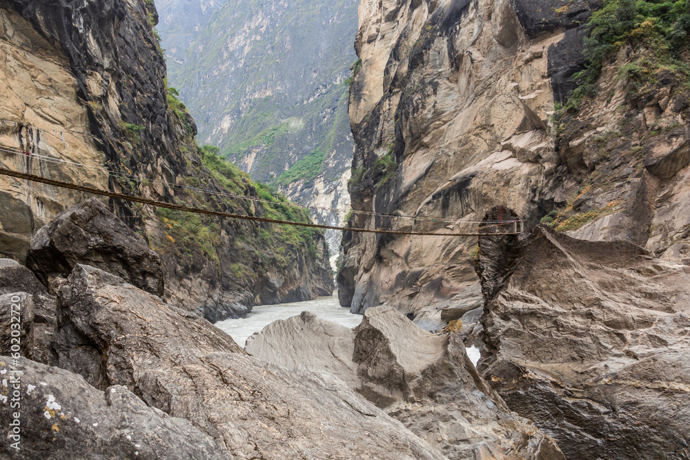 Hanging foot bridge over Jinsha river in Tiger Leaping Gorge, Yunnan province, China