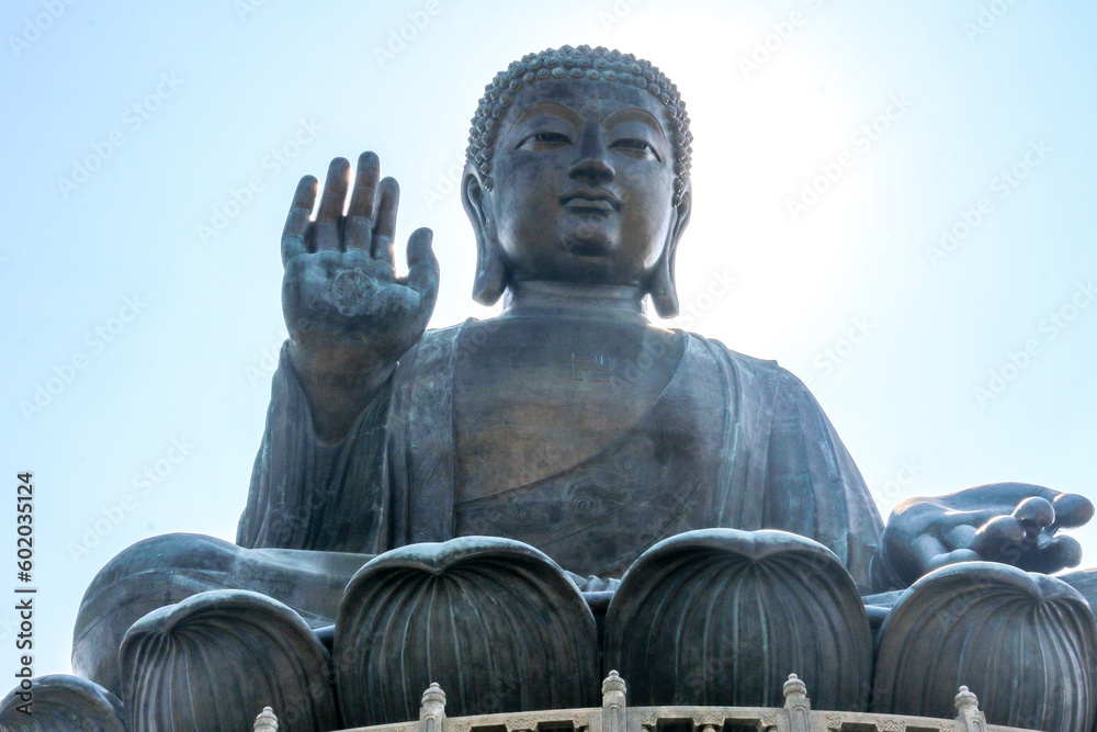 Fototapeta premium The Tian Tan Big Buddha Statue of Buddha Amoghasiddhi sitting and waving at Ngong Ping, Lantau Island, Hong Kong