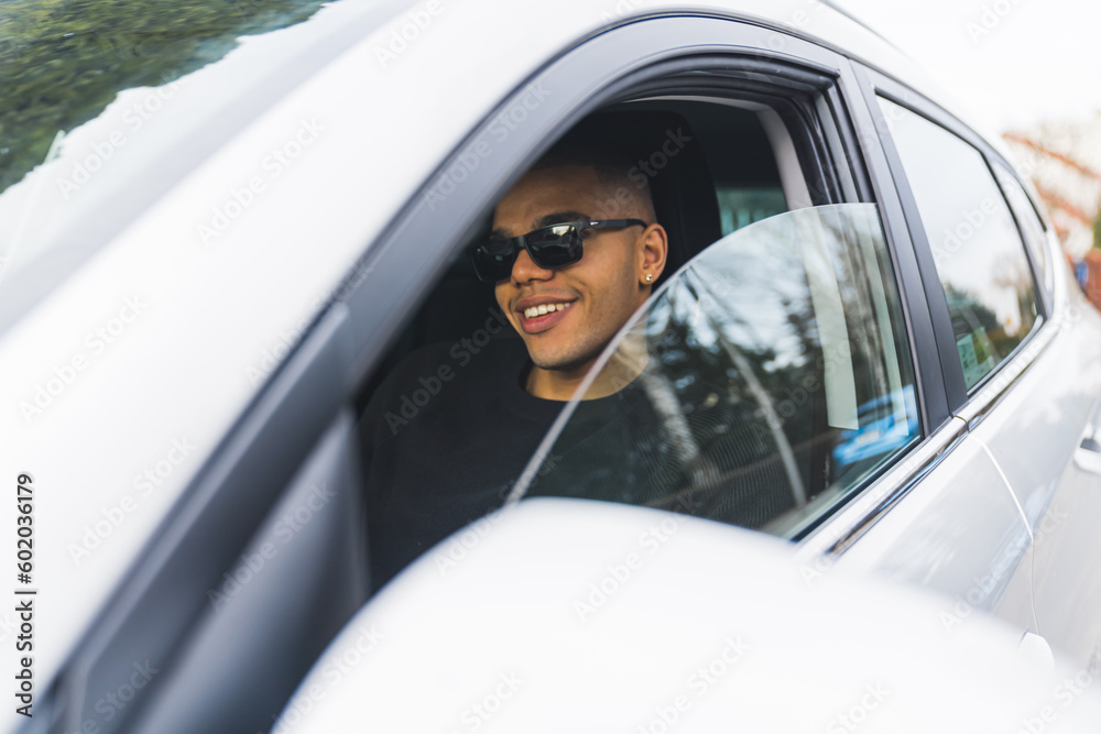 happy bald man with black sunglasses sitting in his car, driving concept. High quality photo
