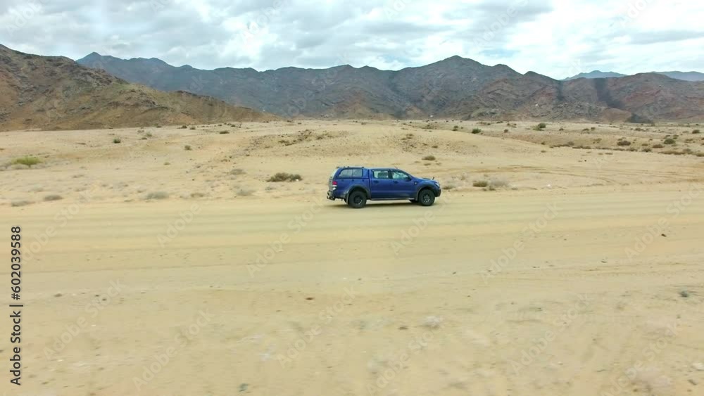 Travel, sand and mountains with truck in dirt road of countryside for freedom, transportation or journey. Adventure, landscape and drone with suv car on road trip vacation for drive, desert or nature Travel, sand and mountains with truck in dirt road of countryside for freedom, transportation or journey. Adventure, landscape and drone with suv car on road trip vacation for drive, desert or nature