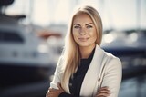 Portrait of a beautiful young blonde woman in a business suit on the background of yachts