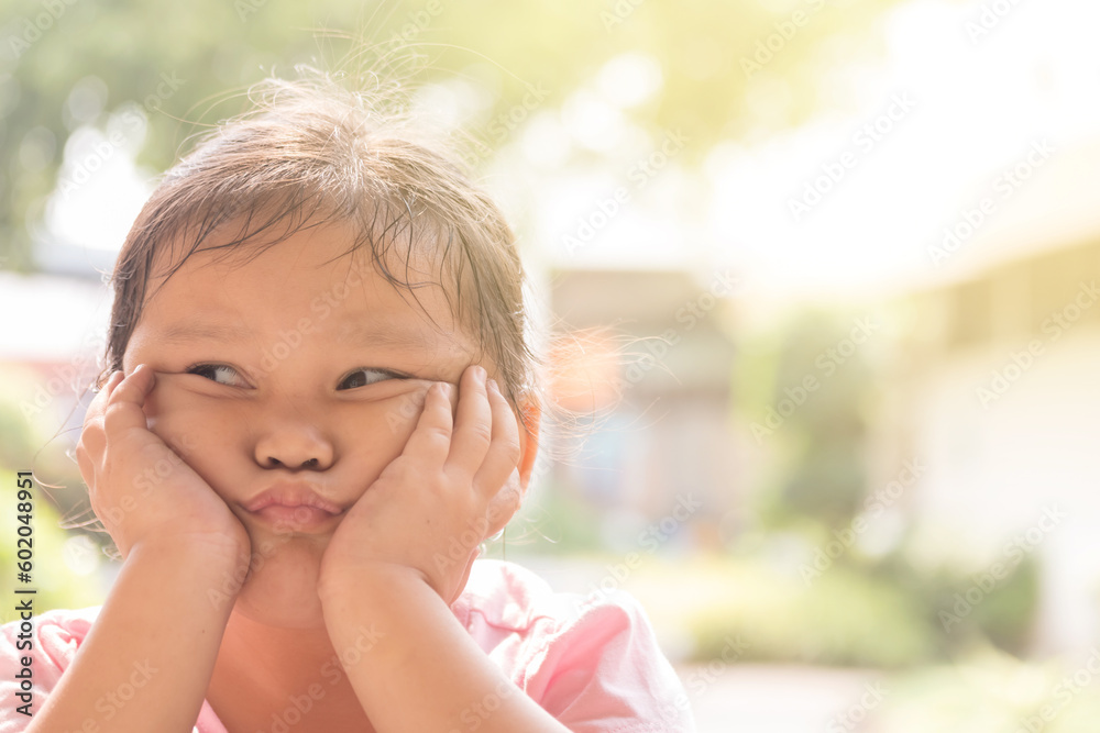 Young Asian girl in pink shirt feeling bored on chair. Depressed girl sits on chair with sad mood. Young Asian girl in pink shirt feeling bored on chair. Depressed girl sits on chair with sad mood.
