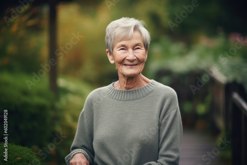 Portrait of a smiling senior woman sitting on a bench in the garden