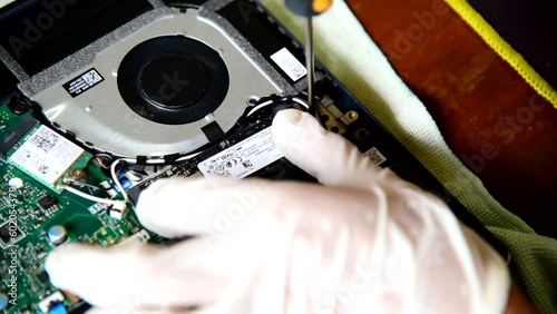 Bangkok,Thailand - May5 , 2023 : Use screwdriver turn the screw for remove  M.2 NVMe SSD storage in the Asus vivobook photo