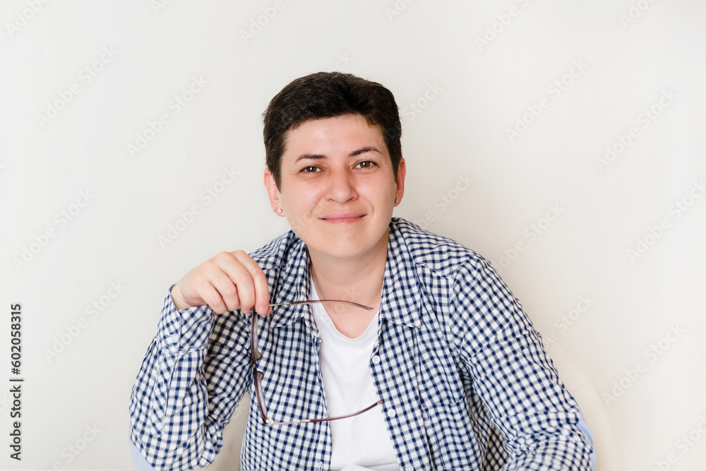 Portrait of an attractive woman sitting at desk, office interior. Smiling woman looking at camera Portrait of an attractive woman sitting at desk, office interior. Smiling woman looking at camera